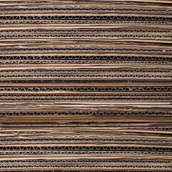 Stacked layers of cardboard with visible corrugated patterns and varying textures, creating a neutral, earthy background.